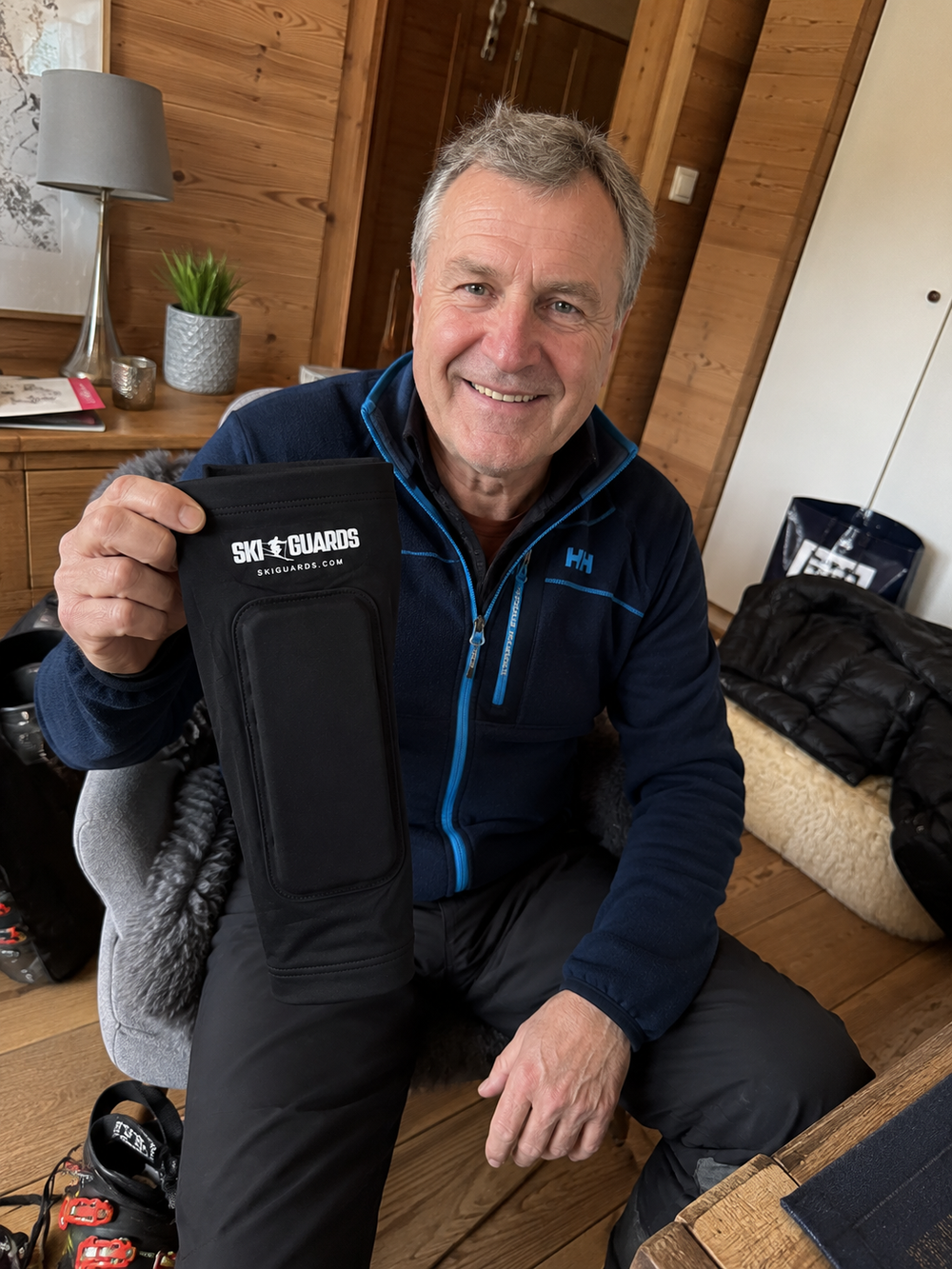 Product-page illustration of a smiling skier holding a SkiGuard sleeve in a lodge
