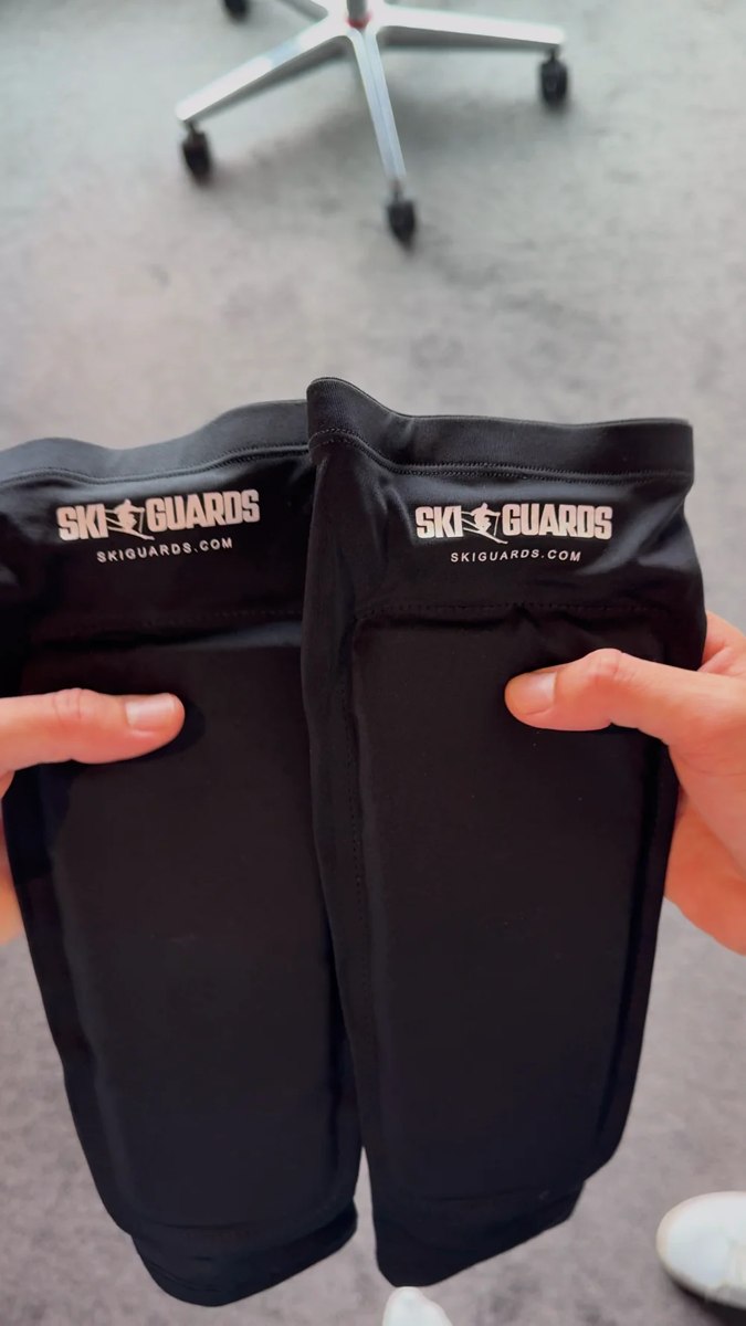 Thumbs pressing the soft front padding of SkiGuard Pro