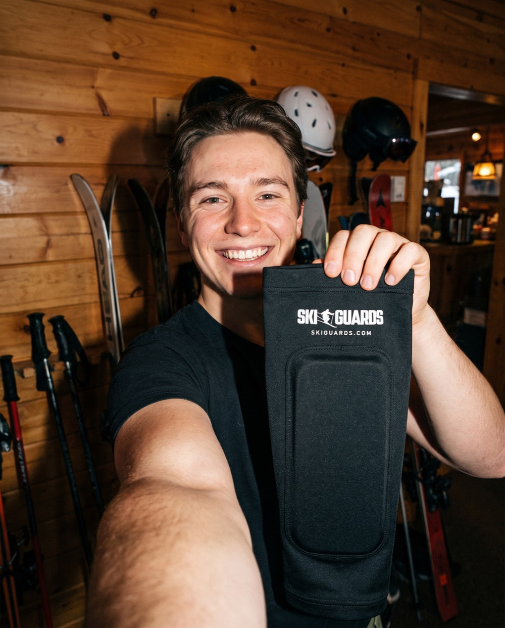 Product-page image of a skier holding a SkiGuard sleeve in a ski lodge